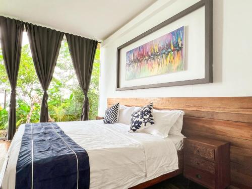 a bedroom with a bed and a painting on the wall at The Dream Beach Resort in Taytay