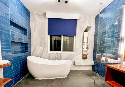 a bathroom with a white tub and blue tiles at The Dream Beach Resort in Taytay