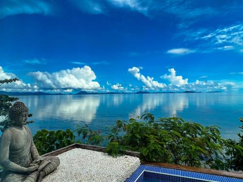 a statue sitting next to a body of water at The Dream Beach Resort in Taytay