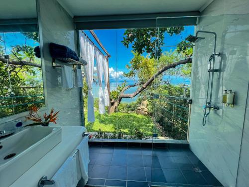 uma casa de banho com um chuveiro, um lavatório e uma janela em The Dream Beach Resort em Taytay
