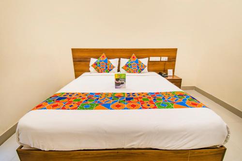 um quarto com uma cama grande e um edredão colorido em FabHotel Thejas Paaradise Coimbatore International Airport em Coimbatore