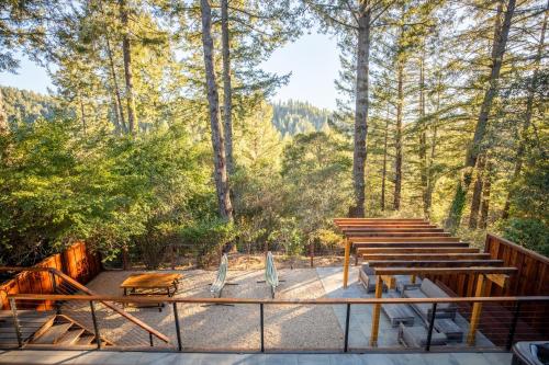a deck with tables and chairs and trees at Valley Vista A Wine Country Escape in Guerneville