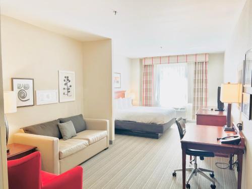 ein Hotelzimmer mit einem Sofa und einem Bett in der Unterkunft Country Inn & Suites by Radisson, Emporia, VA in Emporia