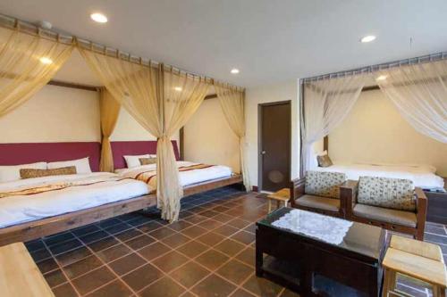 a large room with two beds and a couch at Green Shine B&B in Nanzhuang