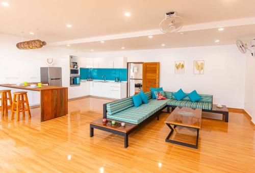 a living room with a green couch and a kitchen at 8 Palm Villa - Private Pool Villas in Aonang in Ao Nang Beach