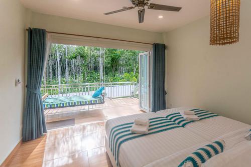 a bedroom with a bed and a large sliding glass door at 8 Palm Villa - Private Pool Villas in Aonang in Ao Nang Beach