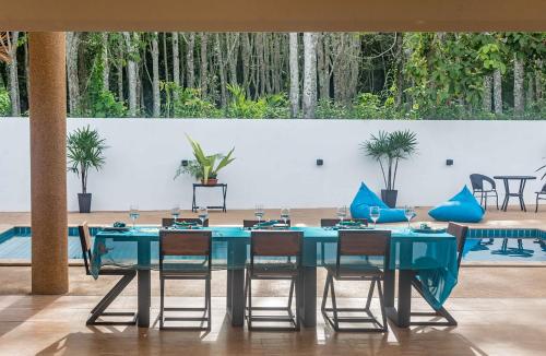 a blue table with chairs in a room with plants at 8 Palm Villa - Private Pool Villas in Aonang in Ao Nang Beach