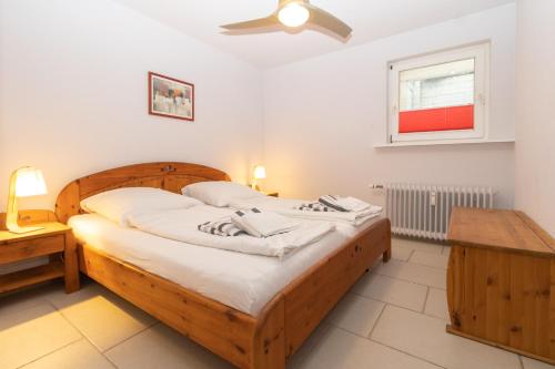 ein Schlafzimmer mit einem großen Holzbett und einem Tisch in der Unterkunft Stranddüne in Hörnum