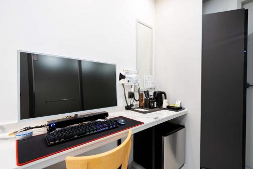 a desk with a computer monitor and a keyboard at Ytt Hotel in Busan