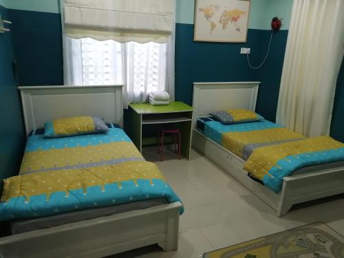 Duas camas num quarto com paredes azuis em Oilclique By The Sea Guesthouse em Dungun