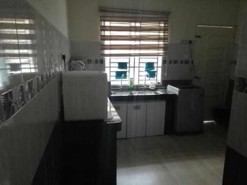 a large kitchen with a sink and a window at Oilclique By The Sea Guesthouse in Dungun