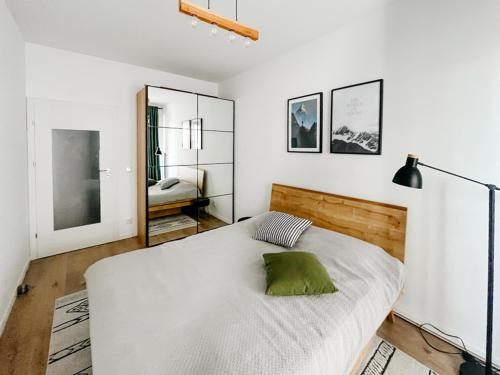 a bedroom with a large white bed with a green pillow at Apartamenty City Tower od WroclawApartament-pl in Wrocław