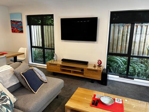 a living room with a couch and a flat screen tv at Coronet Haven in Queenstown