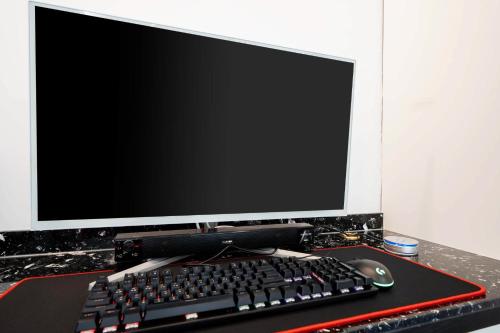 a computer monitor and a keyboard and mouse on a desk at Ytt Hotel in Busan