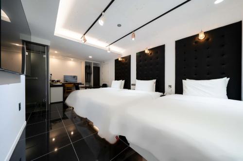 a hotel room with two beds and a kitchen at Ytt Hotel in Busan
