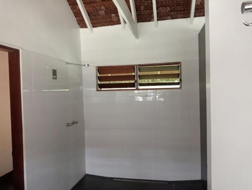 Habitación con pared blanca y ventana en Solwata House, On the Water Sleeps 6, en Port Vila