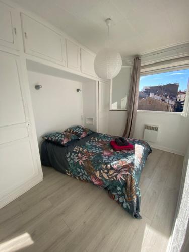 une chambre avec un lit et une grande fenêtre dans l'établissement Le 35 Liberté-Spacieux appartement avec balcon et local vélos-Centre Commercial Polygone Béziers, à Béziers