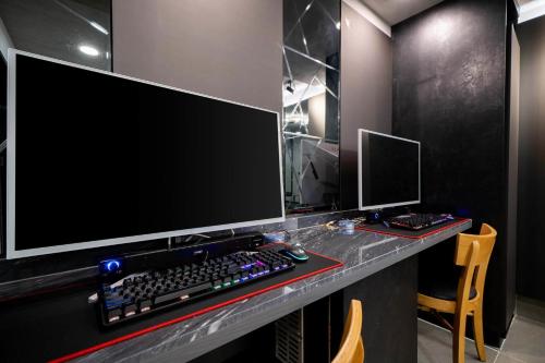 a desk with a computer monitor and a keyboard and mouse at Ytt Hotel in Busan