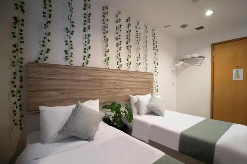 two beds in a hotel room with white sheets at Victoria Hotel a NuVe Group Collection in Singapore