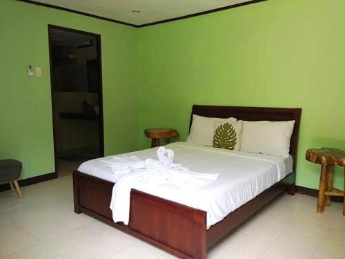 a bed in a room with a green wall at Arapal Nature Retreat in Bogo