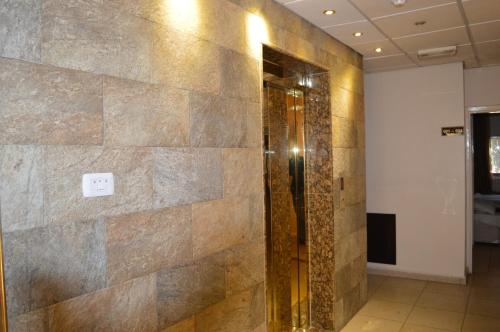 a bathroom with a shower with a stone wall at Salome Hotel in Madaba