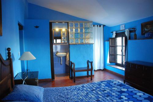 a blue bedroom with a bed and a sink at Posada La Casa Grande in Jimena de la Frontera