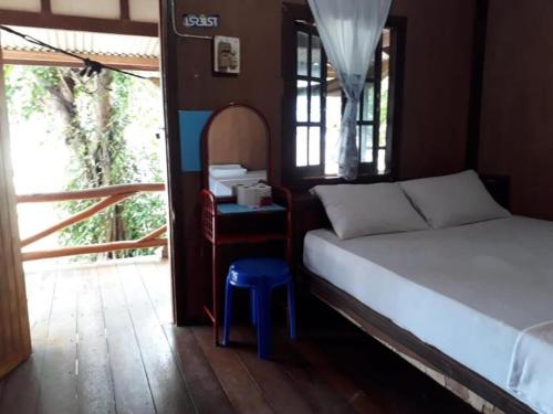 ein Schlafzimmer mit einem Bett und einem blauen Stuhl in der Unterkunft Pinks Bungalow in Baan Tai
