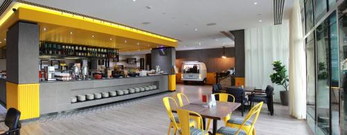a restaurant with a table and chairs and a bar at Hyatt Place Dubai Al Rigga in Dubai