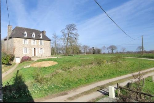 een groot huis in een veld met een weg bij Maison de Maître - chambre chez particulier in Landéan