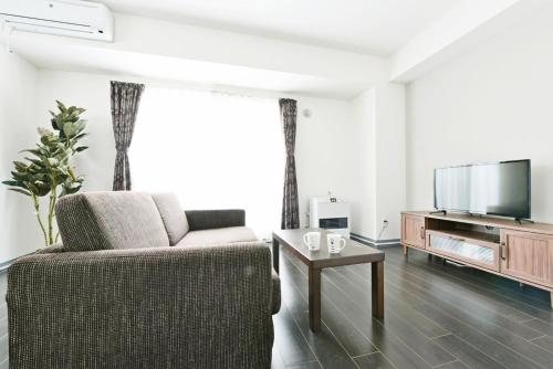 a living room with a couch and a flat screen tv at Sun Court Hondori Garden Hills in Tsukisappu