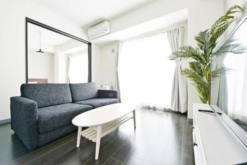 a living room with a couch and a table at Sun Court Hondori Garden Hills in Tsukisappu
