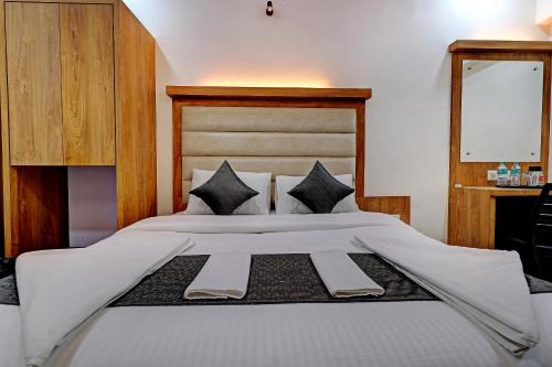 a bedroom with a large white bed with black pillows at Sun Inn Residency Rabale in Navi Mumbai