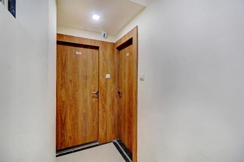 a hallway with a wooden door in a room at Sun Inn Residency Rabale in Navi Mumbai