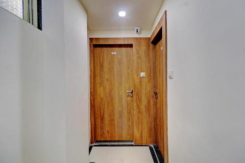a hallway with a wooden door and a bench at Sun Inn Residency Rabale in Navi Mumbai