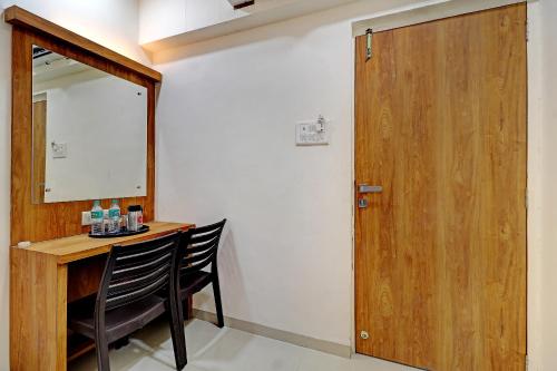 a room with a desk and a mirror and a wooden door at Sun Inn Residency Rabale in Navi Mumbai