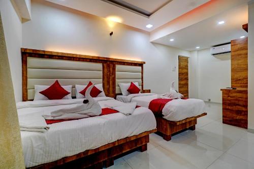 a bedroom with two beds with white and red pillows at Sun Inn Residency Rabale in Navi Mumbai