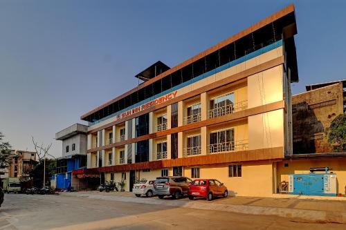 a building with two cars parked in front of it at Sun Inn Residency Rabale in Navi Mumbai