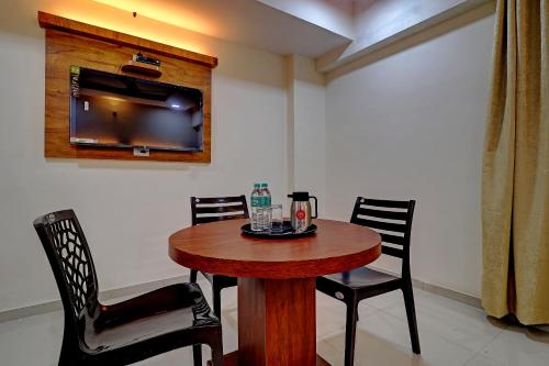 a dining room table with two chairs and a television at Sun Inn Residency Rabale in Navi Mumbai