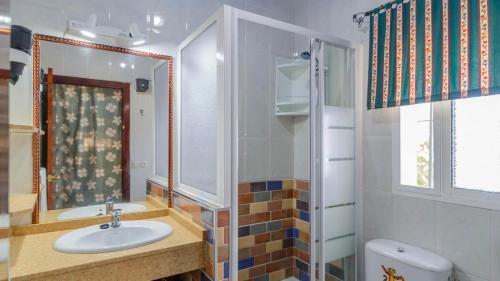 ein Badezimmer mit Waschbecken, Spiegel und Toilette in der Unterkunft El Castillejo Alpandeire by Ruralidays in Alpandeire