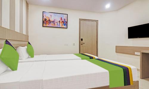 a bedroom with a large bed and a tv at Treebo Arastu Grand in Hyderabad