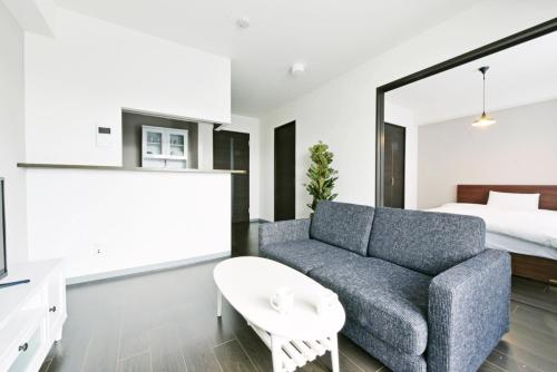 a living room with a couch and a bed at Sun Court Hondori Garden Hills in Tsukisappu