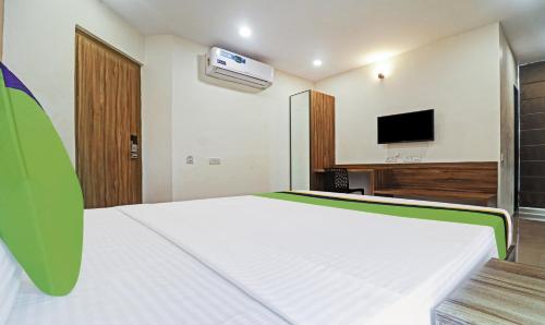 a bedroom with a white bed and a tv at Treebo Arastu Grand in Hyderabad