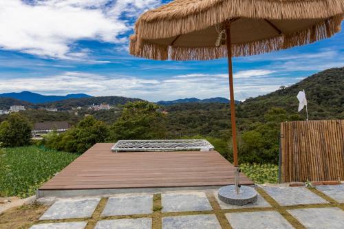 a wooden deck with an umbrella and a table at Stellar GoldenHill Cameron in Tanah Rata