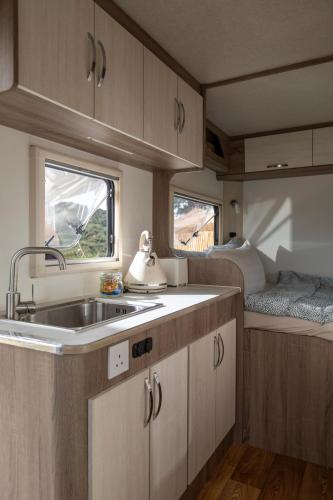 a kitchen in an rv with a sink and a bed at Stellar GoldenHill Cameron in Tanah Rata