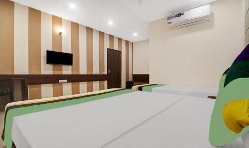 a room with a bed and a tv on a wall at Treebo Arastu Grand in Hyderabad