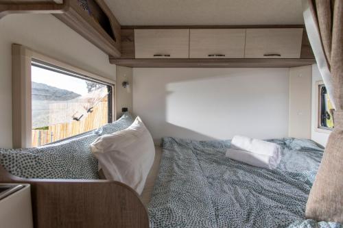 a bedroom in an rv with a bed and a window at Stellar GoldenHill Cameron in Tanah Rata