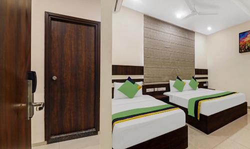 a room with two beds and a door in it at Treebo Arastu Grand in Hyderabad