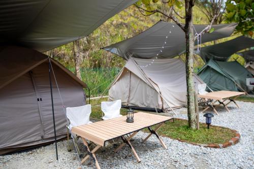 a picnic table and chairs in front of a tent at Stellar GoldenHill Cameron in Tanah Rata