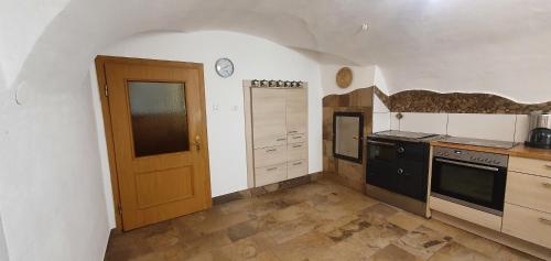 a kitchen with a black stove and a door at Haus Stoffenhof in Rosenberg