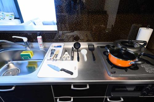 a kitchen counter with a sink and a pot on a stove at Baycourt Otaru in Kita-hamachō